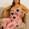 Close-up of printed satin fabric showing Love, hearts, and floral rose patterns for women’s night suit.